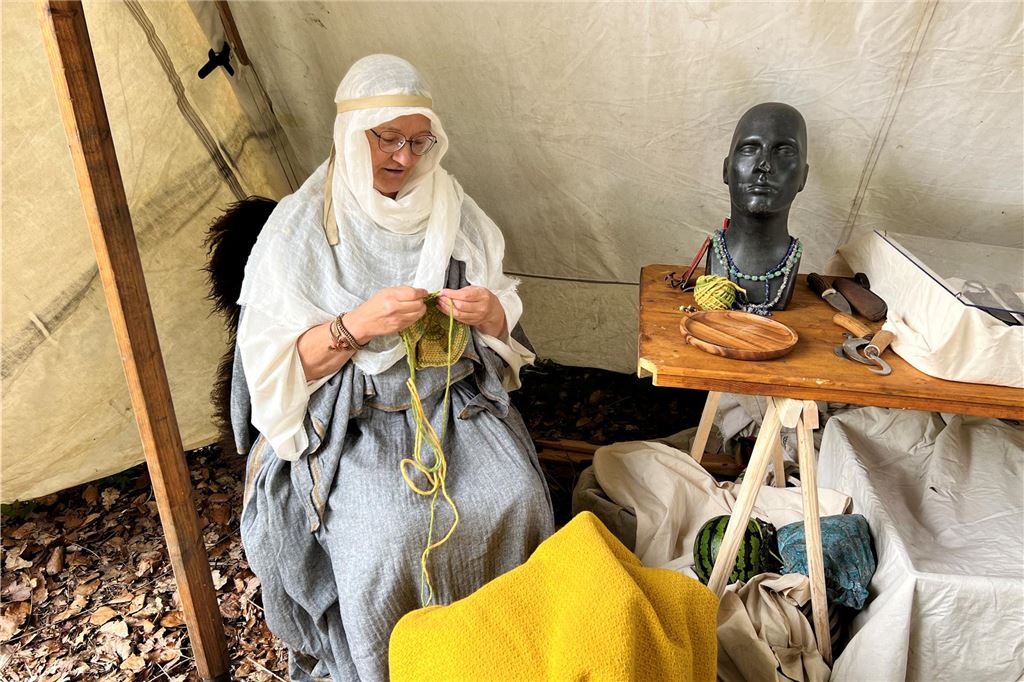 Eine Frau strickt im Römerpark. 