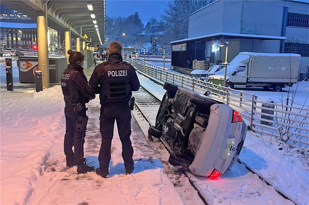Schnee und Eis verursachen viele Unfälle in NRW: Zwei Verletzte bei Kollision in Herdecke – Newsblog Ein Auto liegt auf der Seite auf den Gleisen.