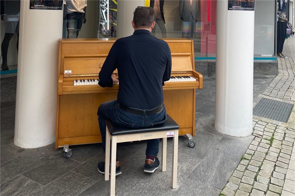 Klavier, Sand und Liegestühle: Stadtmarketing startet in Sommersaison Ein Mann sitzt an einem Klavier in der Unnaer Innenstadt und spielt.