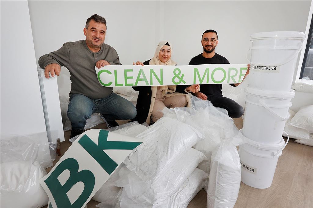 Diese Läden haben 2024 eröffnet und geschlossen Erdine Özcelik, Mitarbeiterin Ayfe Evli und Mitarbeiter Apo Alnasser sitzen auf einem Stapel von Waschmittel und halten ein "Clean and More"- Schild in die Kamera.