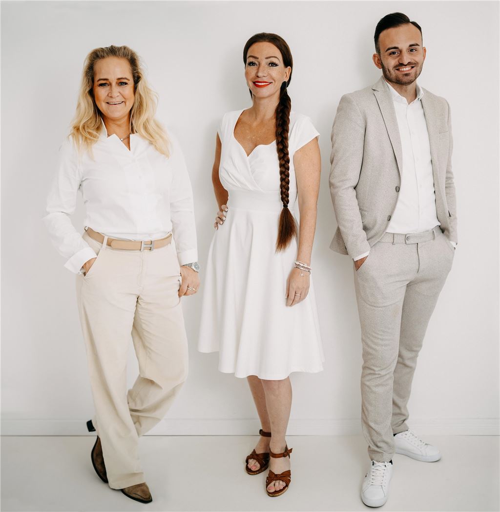 Silke Duis verhilft Menschen zu ihrem Traumhaus Ivonne Binkowski, Silke Duis und Nico Thoneick stehen in heller Kleidung auf einem Gruppenfoto.