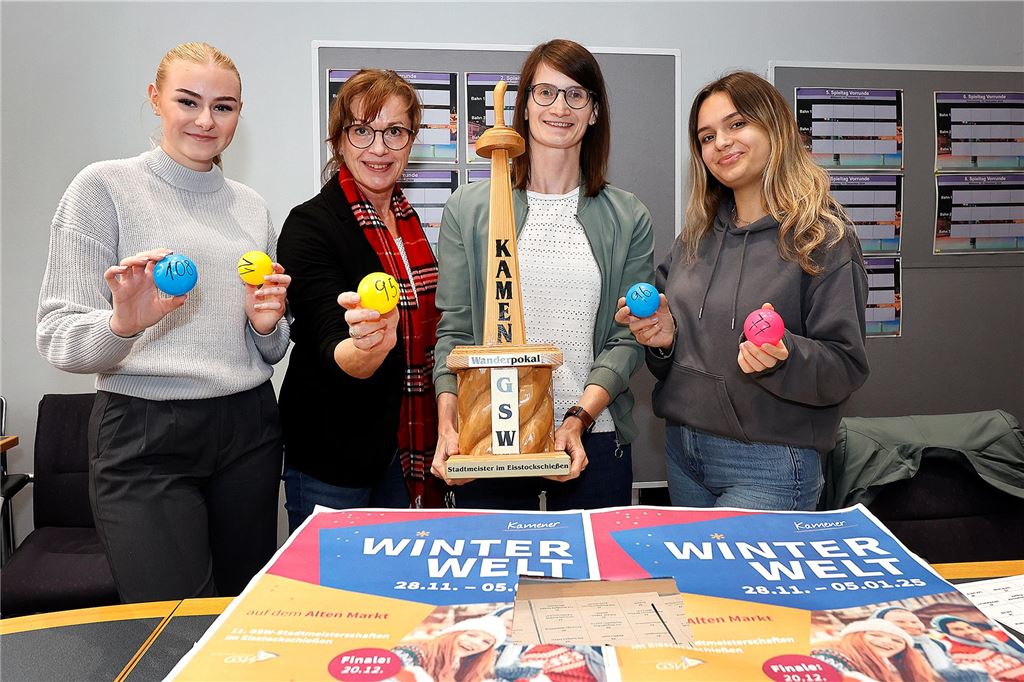 Eisstockschießen 2024: Auslosung der Teams ist gelaufen Vier Frauen präsentieren Losbälle und einen Wanderpokal.