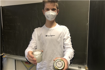 Julian Hesse von der Schülerfirma am PGU zeigt die Kerzen, die er und seine Mitschüler selbst gegossen haben und nun zum Verkauf anbieten.