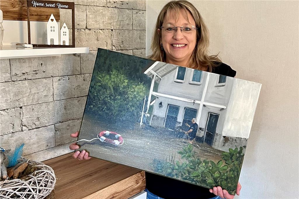 Hochwasser-Opfer blickt zurück: „Der schlimmste Tag meines Lebens“ Katja Westhoff mit einem Bild ihres Hauses während der Flut.