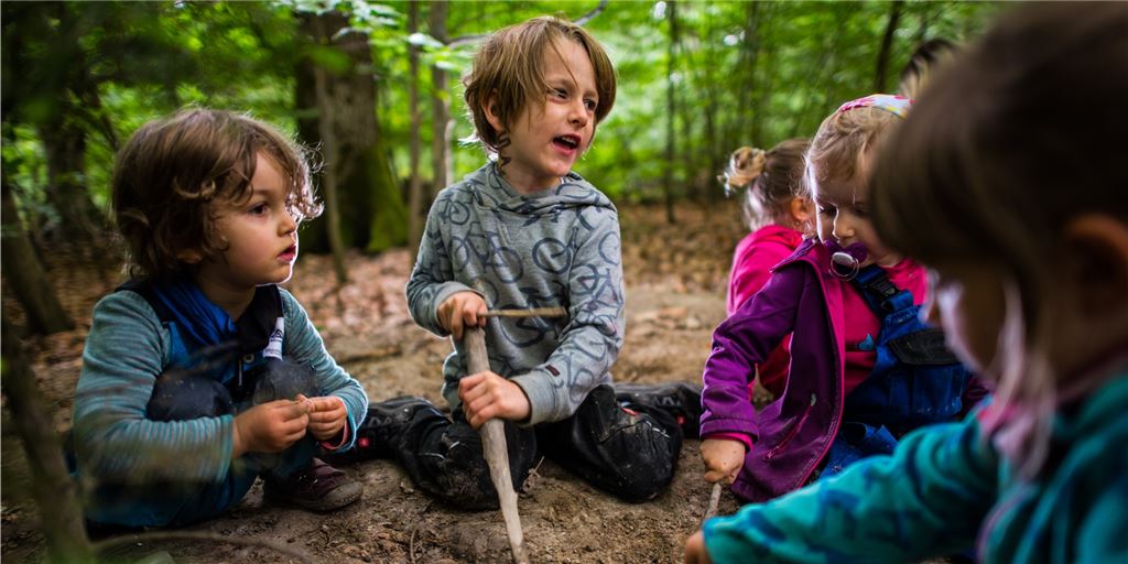 Gibt es bald einen Waldkindergarten im Kreis Unna? Kinder eines Waldkindergartens spielen mit Matsch im Wald. Vielleicht gibt es in Zukunft auch einen Waldkindergarten im Kreis Unna.