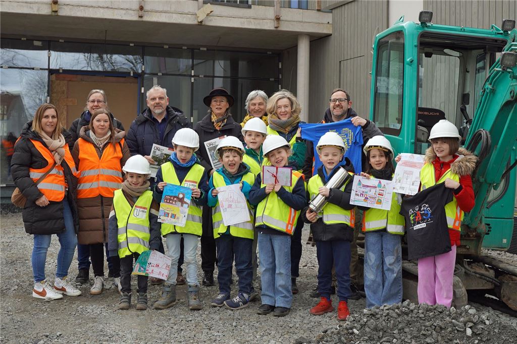 Schulweg für Autofahrer: ADFC enttäuscht über neuen Kreisverkehr Eine Gruppe von Kindern steht mit Bauarbeiterhelm und Signalweste vor dem künftigen Bildungszentrum am Hertinger Tor in Unna. Bei dem Baustellenbesuch durften sie eine Zeitkapsel mit Dokumenten befüllen, die im Gebäude eingearbeitet wird.