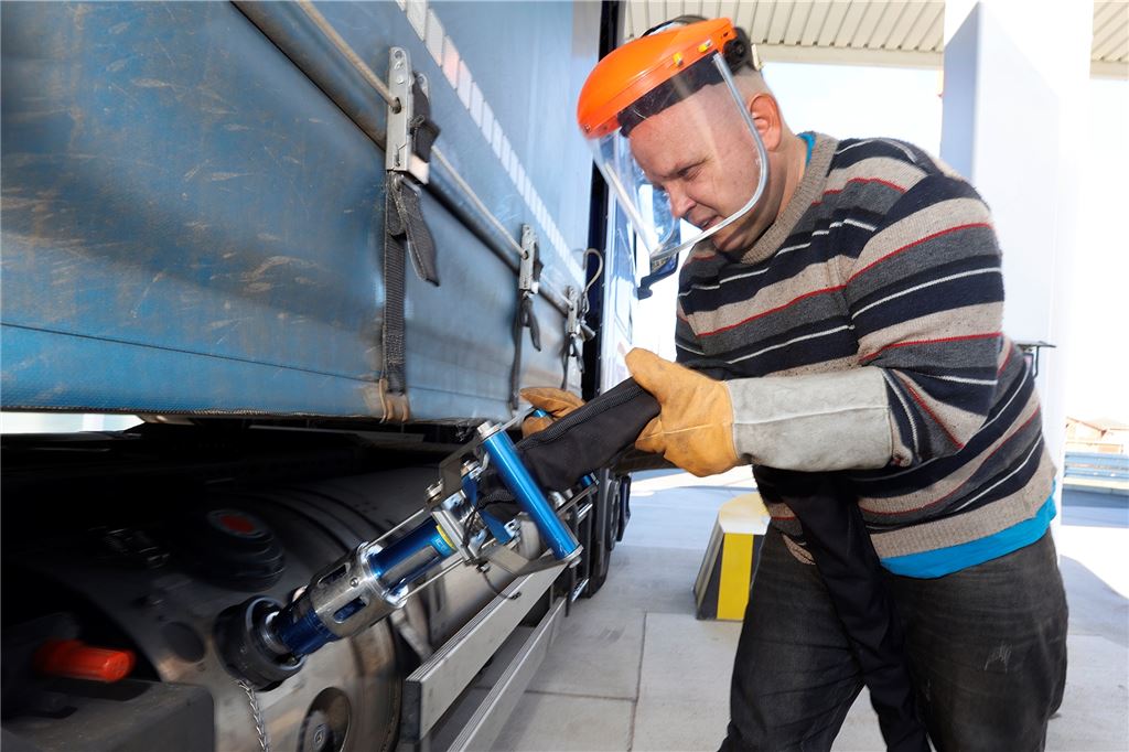 Tanken bei minus 162 Grad, um den Spritpreisen ein Schnippchen zu schlagen Lkw-Fahrer Vladimir Dzimuanon hat den Gesichtsschutz übergezogen und den Tankstutzen angesetzt.