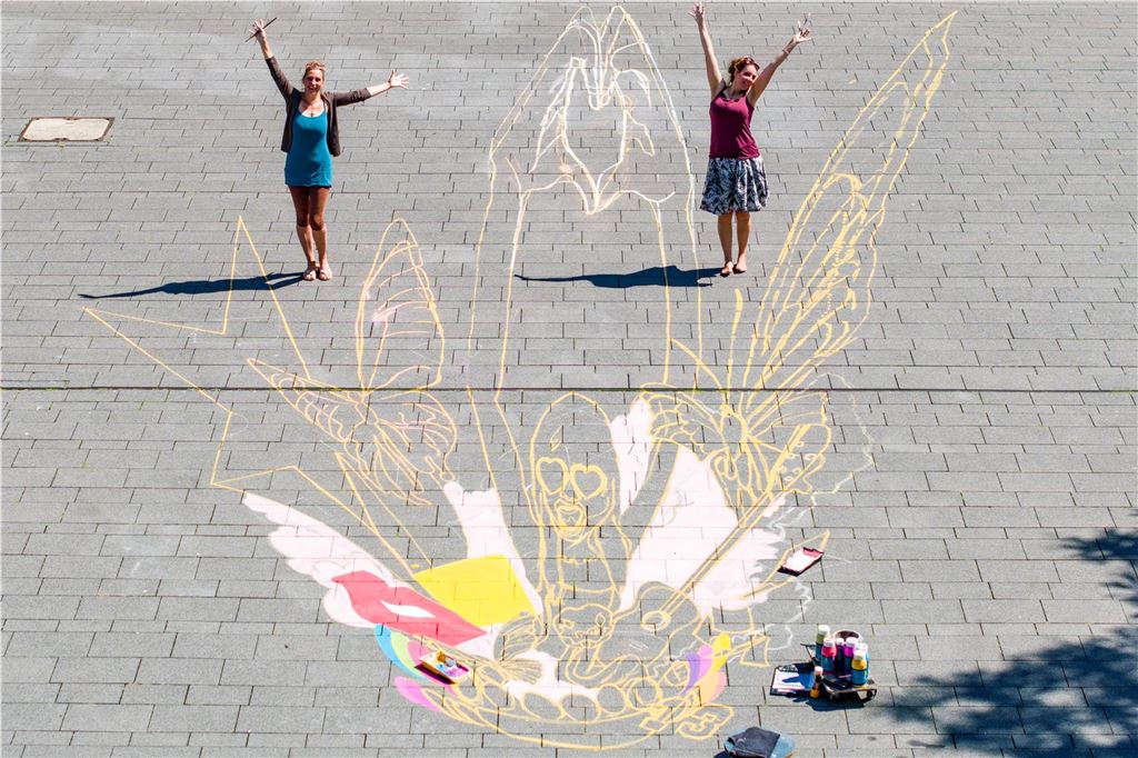 Mega-Hype um Taylor Swift in Gelsenkirchen: Erste Fans am Stadion, Riesen-Kunstwerk in der City Lydia (l.) und Vanessa Hitzfeld malen ein riesiges Taylor-Swift-Bild vor dem Hans-Sachs-Haus in der Innenstadt von Gelsenkirchen.