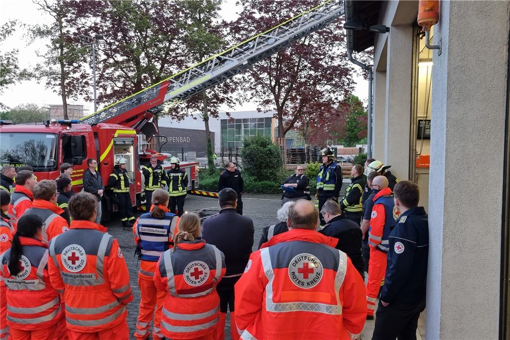 DRK- und Feuerwehrleute bei der Besprechung der Übung.