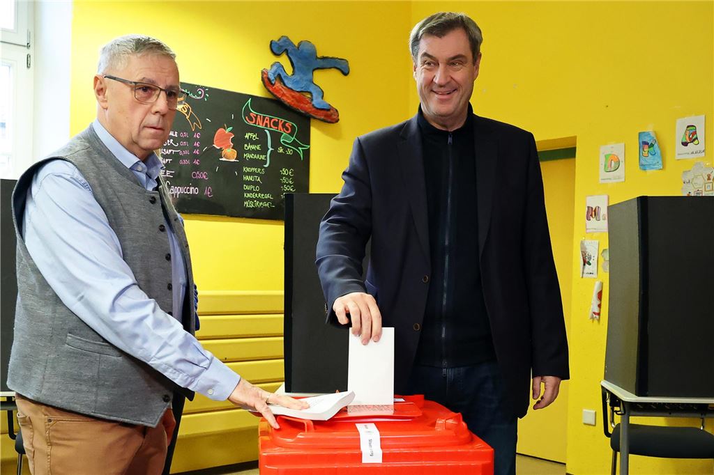 Deutschland wählt eine neue Regierung: Der Newsblog zum Bundestagswahltag 2025 Markus Söder (CSU, r), Ministerpräsident von Bayern, gibt in einem Wahllokal in einer Schule seine Stimme ab.