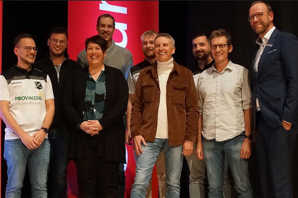 Mirco Rienhoff von der Sparkasse UnnaKamen und die Sieger der Kategorie Sport des Vereinsprojekts auf der Bühne der Stadthalle Unna.
