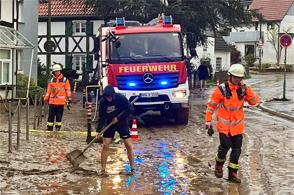 Mit vereinten Kräften wurde die Straße vom Schlamm befreit.