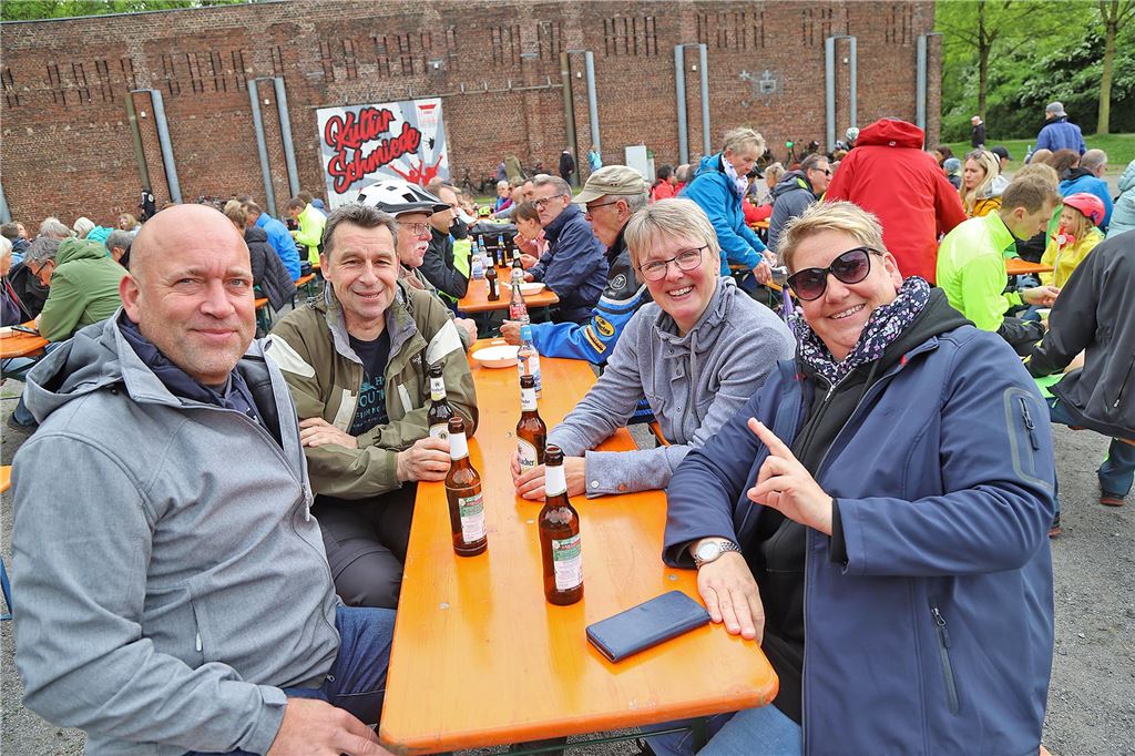 Menschen sitzen auf einer Bank und trinken.