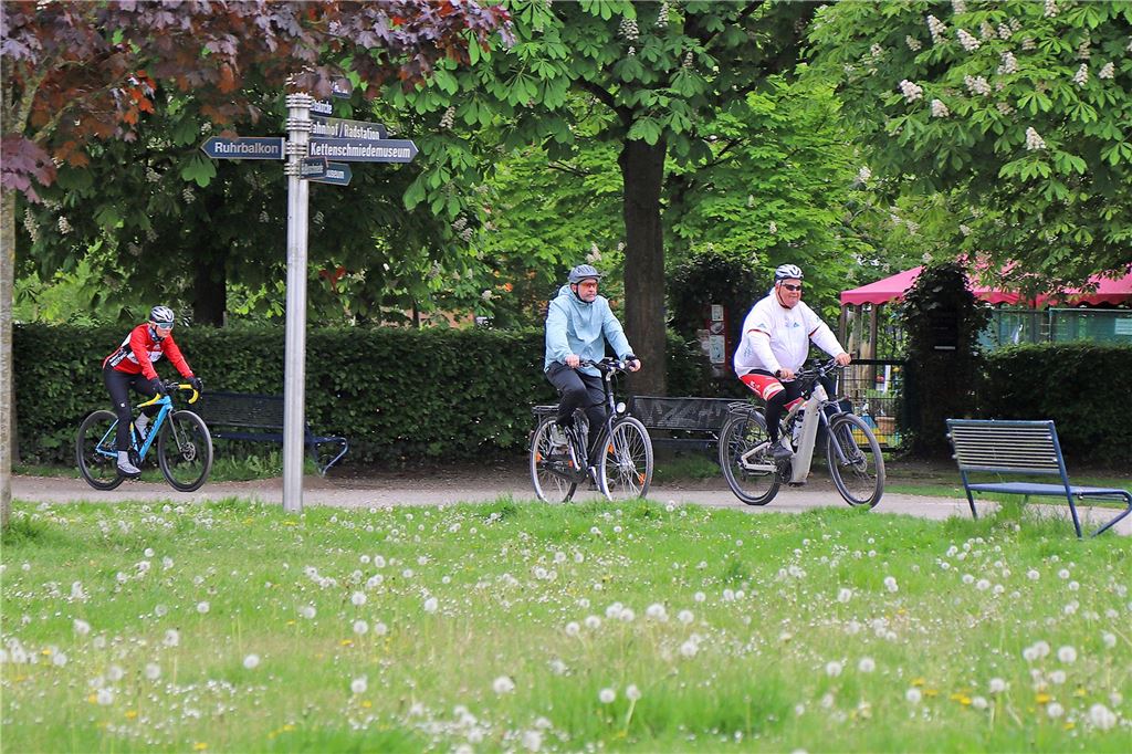 Menschen mit Helm auf einem Fahrrad, die gerade nach ihrer Route am Ziel ankommen.