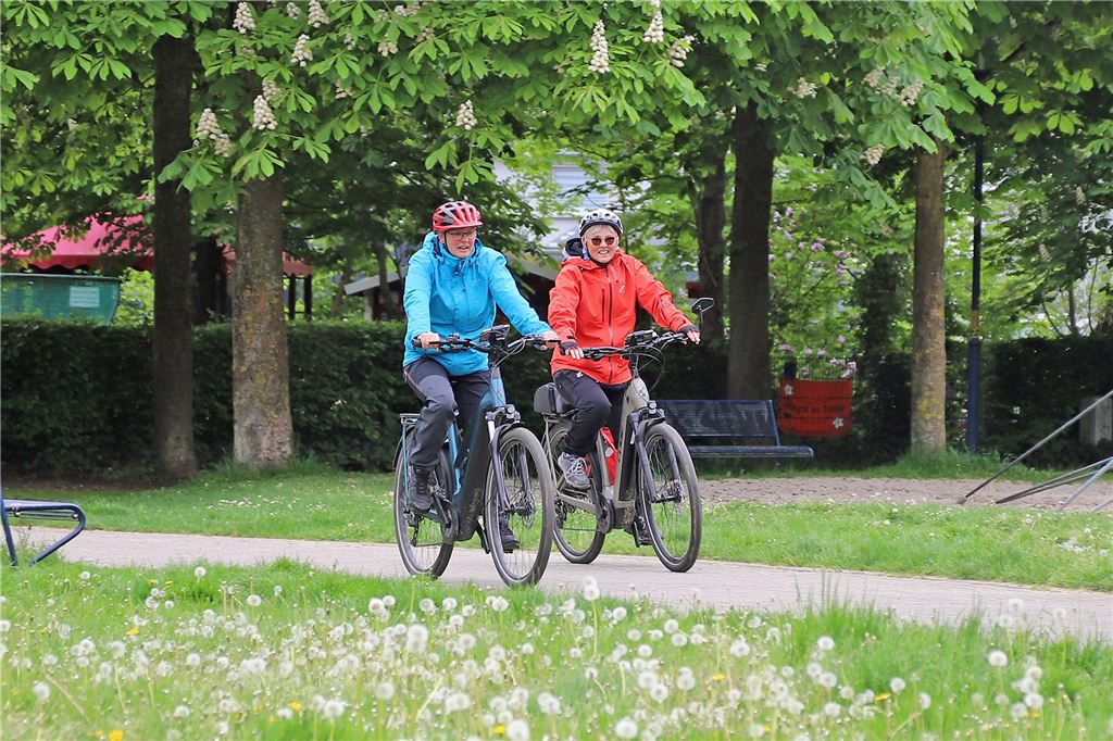 Menschen mit Helm auf einem Fahrrad, die gerade nach ihrer Route am Ziel ankommen.