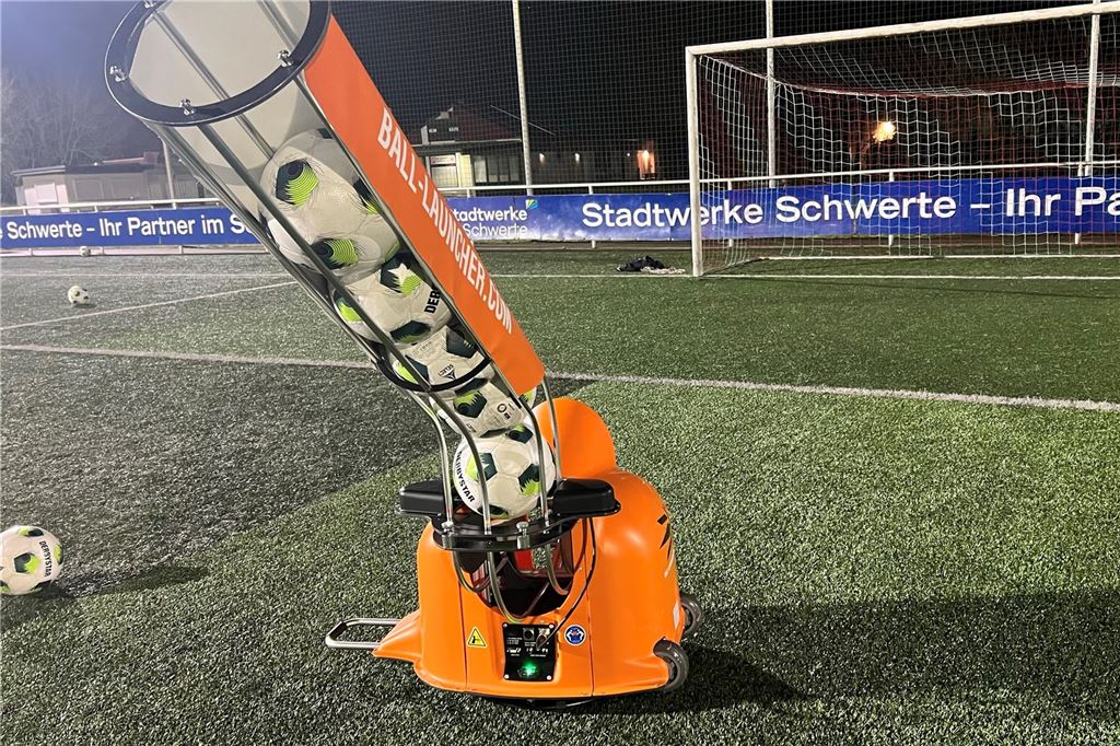 Geisecker SV hat in innovatives Trainingsgerät investiert: „Männer-Spielzeug“ für Torhüter Eine mit fünf Bällen gefüllte Ballmaschine steht auf einem Kunstrasenplatz.