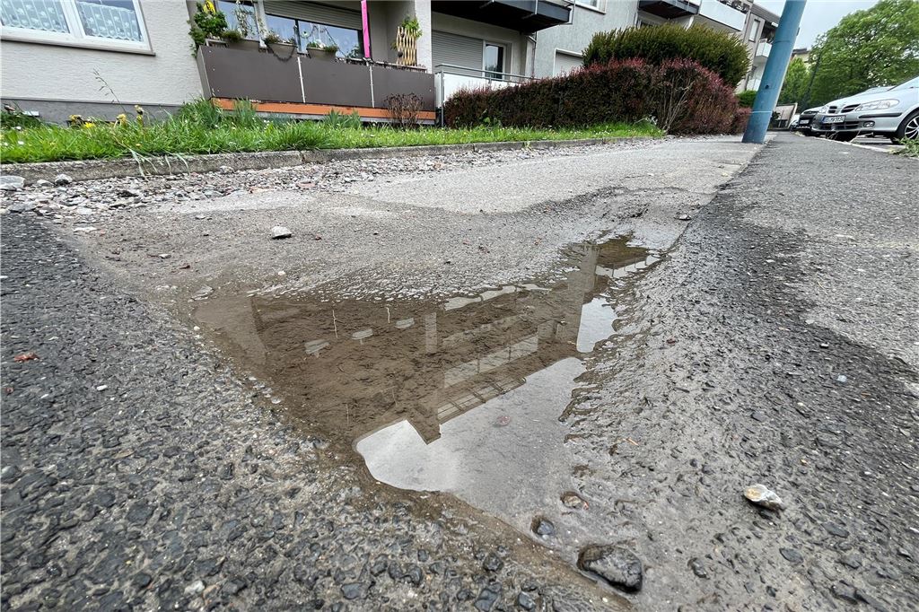 Anwohnerin mahnt: Wege werden durch Glasfaserausbau zu Stolperfallen Eine Pfütze auf einem Gehweg in Holzwickede füllt ein Schlagloch aus.