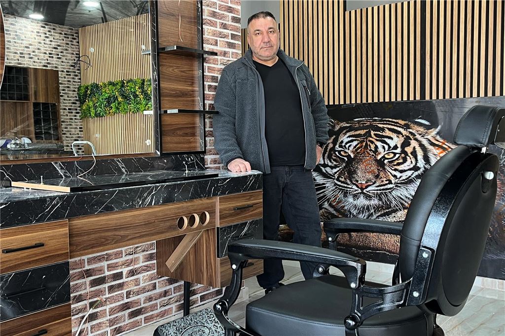 Osman Daham (53) übernimmt Ladenlokal der ehemaligen Volksbank Osman Daham steht in einem Friseursalon neben einem Friseurstuhl und einem Waschtisch. Im Hintergrund ist ein Bild eines Tigers zu sehen.
