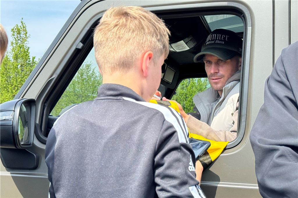 Pascal Groß gibt einem Fan ein Autogramm.