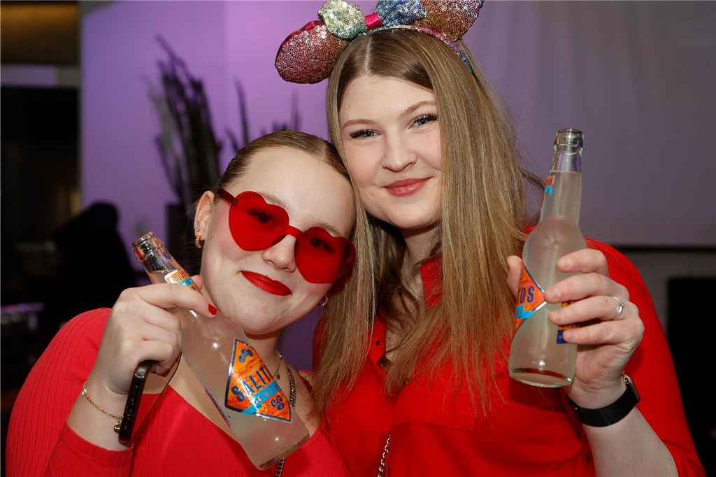 Zwei Frauen lächeln in die Kamera. Sie halten je eine Flasche Salitos hoch.