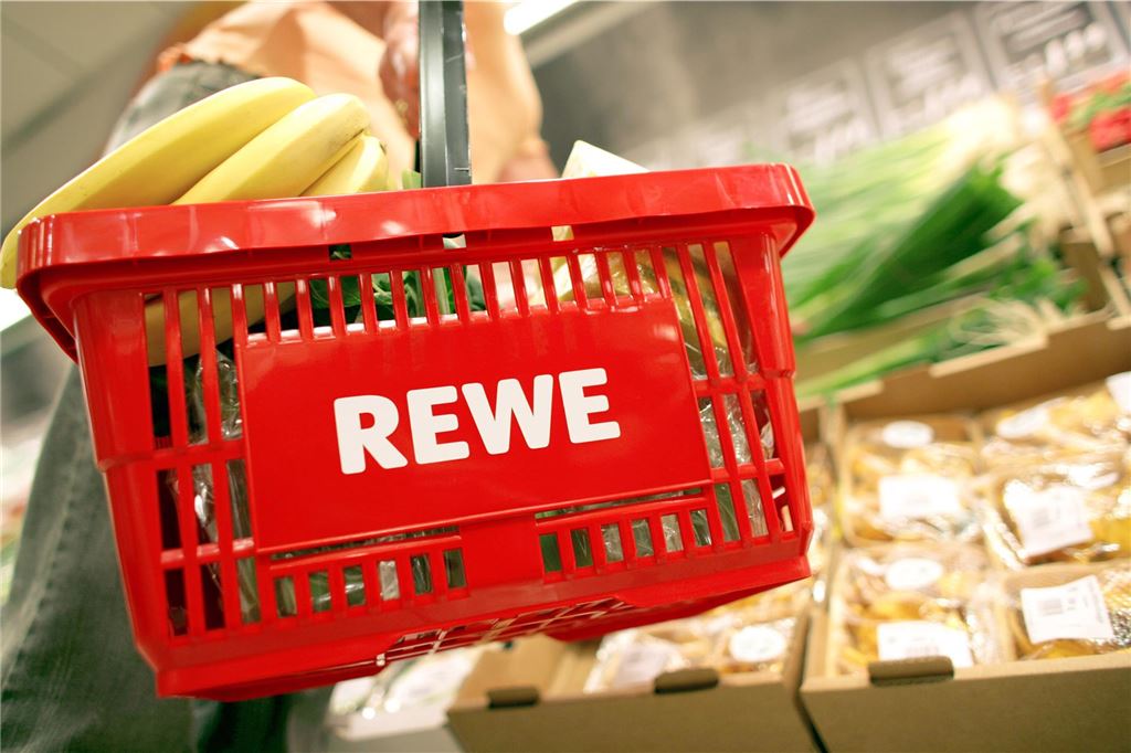 Rewe verteidigt Kameraüberwachung und sucht Gespräch mit Betreiber Eine Frau hat einen Rewe-Einkaufskorb in der Hand.
