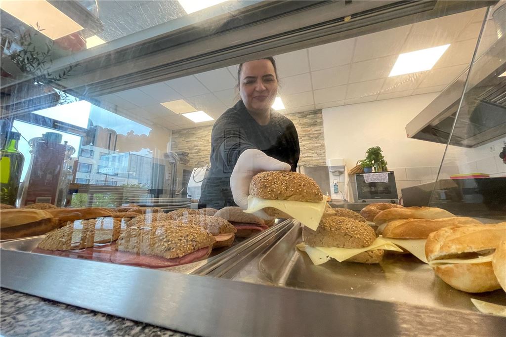 Café Glück eröffnet am Eco Port, in Flughafennähe Nahaufnahme, Sedef Senöz füllt neue Brötchen in die Theke ein.