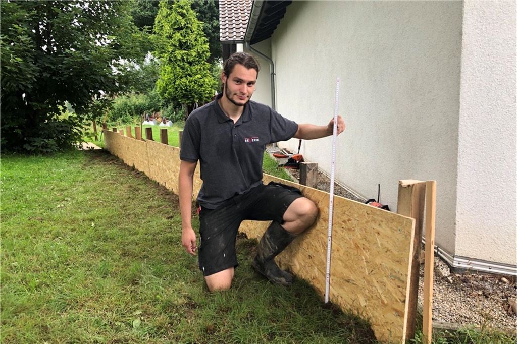 Aktionismus der CDU hilft nicht: Schutz vor Regenfluten längst bekannt Ein Mitarbeiter der Schreinerei Severin baut 2021 eine Spundwand vor dem Feuerwehrhaus in Fröndenberg-Warmen.