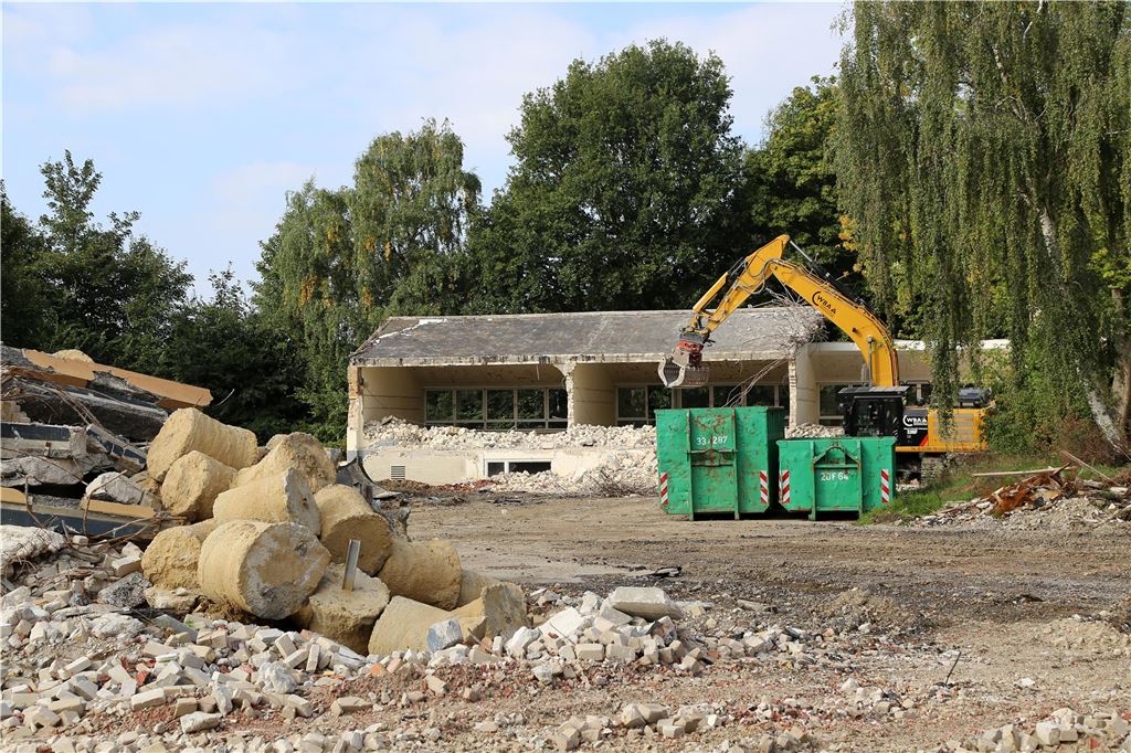 Politiker fordern Wohnraumplanung mit mehr Druck in Massen-Nord Das Archivbild von 2025 zeigt einen Abrissbagger und grüne Schuttcontainer auf dem Gelände der ehemaligen Gerhart-Hauptmann-Schule in Massen