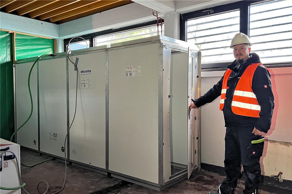 Eishallen-Abriss: Feierabend liegt hinter der Asbest-Schleuse Sergej Jakubov von der E&K-Gruppe an der Asbestschleuse. In ihr finden sich vier Kammern, in denen sich die Arbeiter beim Weg nach draußen von schädlichen Fasern befreien. Hinter der Schleuse – abgeschirmt durch die grüne Folie – arbeiten sie in der Eissporthalle Unna an asbesthaltigem Material.
