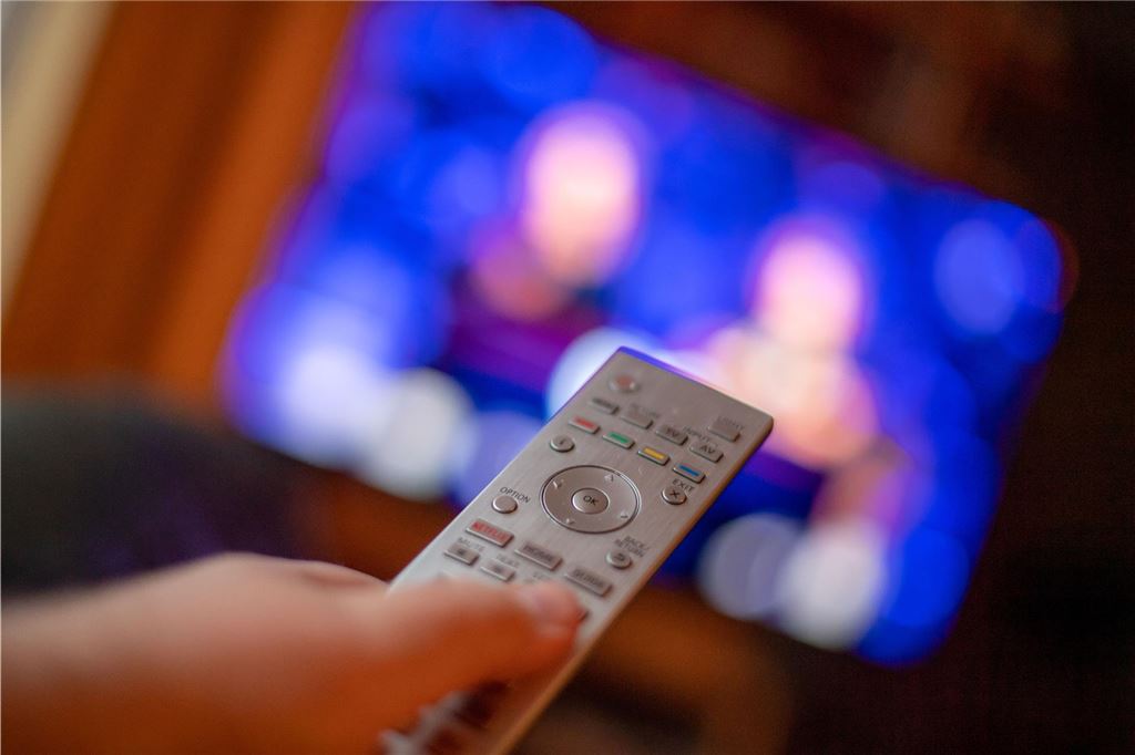 Familie bedeutet immer Schwund Eine Fernbedienung wird vor einem Fernseher gehalten.