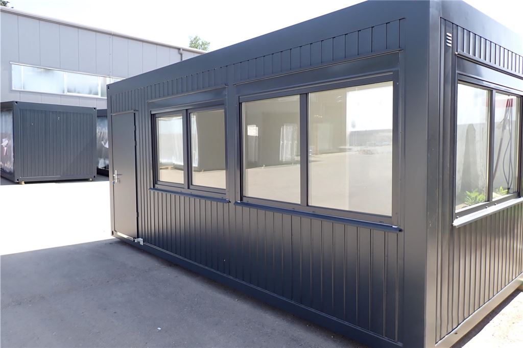 Wohncontainer für Geflüchtete? Stadt lädt zu zweiter Infoveranstaltung Ein schwarzer Container mit mehreren Fenstern und einer Tür.