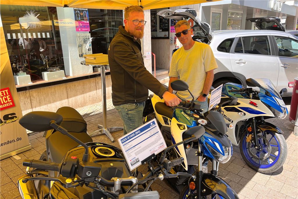 Bilder von der Mobilitätsschau am verkaufsoffenen Wochenende: Da ist für alle was dabei! Zwei Männer stehen zwischen geparkten Motorrädern unter einem Pavillon.