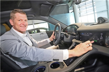 Standortleiter Christoph Kösters zeigt, wie es im Inneren des Porsche Taycan aussieht. Das Elektroauto hatte zuletzt viele Neukunden angezogen.