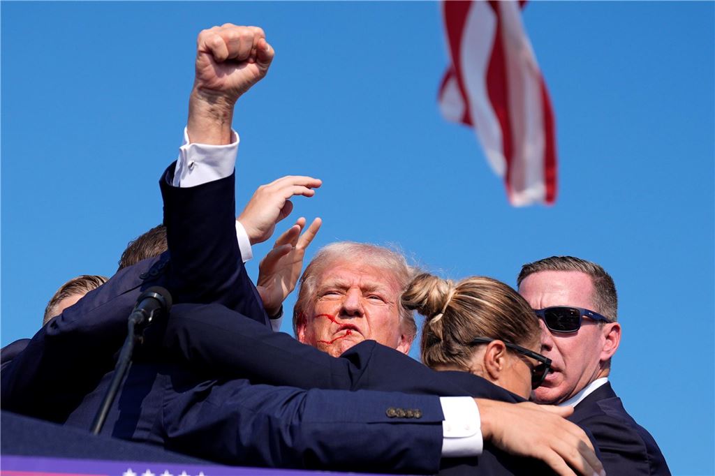Attentat auf Trump: Ex-Präsident blutet nach Schüssen Trump hebt beim Abgang auf der Bühne seine Faust.