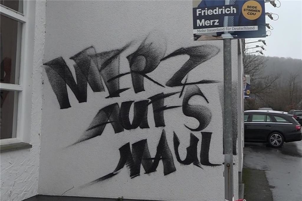 Sachbeschädigung vor CDU-Neujahrsempfang: Jetzt ermittelt der Staatschutz Auf der Schützenhalle Hüingsen steht die aufgesprühte Parole "Merz aufs Maul" neben einem Plakat mit dem Spitzenkandidaten der CDU Friedrich Merz.