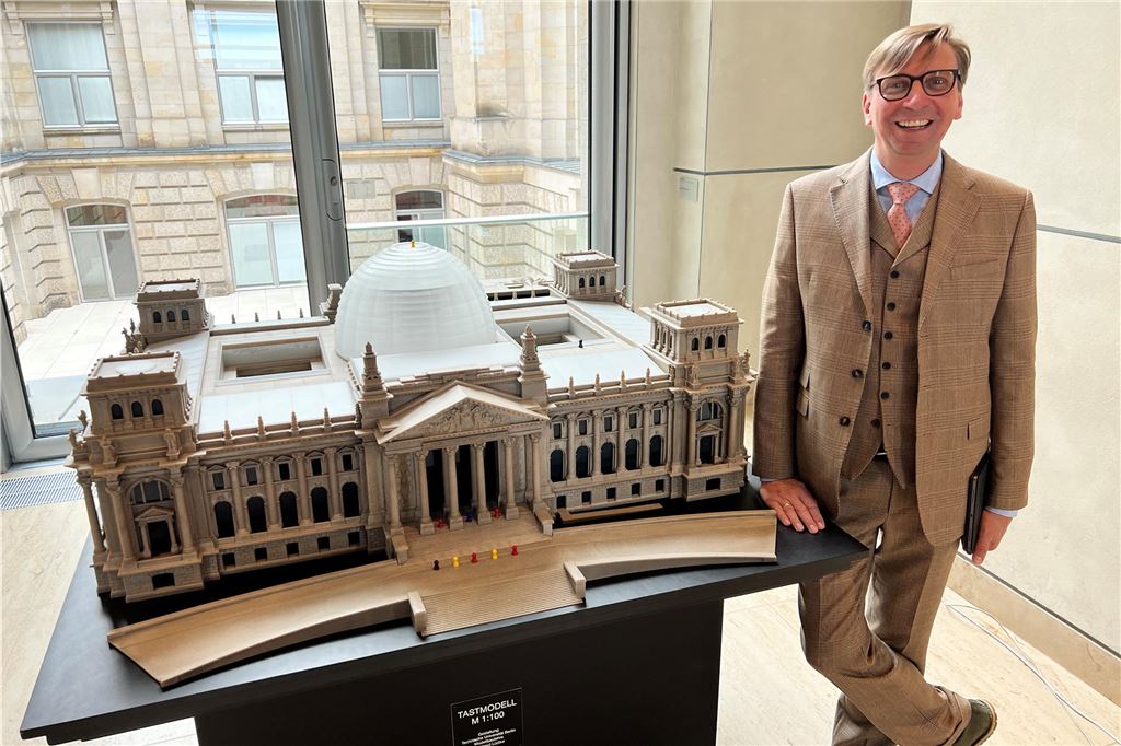Als Michael Sacher plötzlich noch einmal Weltpolitik machte Bundestagsabgeordneter Michael Sacher steht neben einem Modell des Reichstagsgebäudes in Berlin.