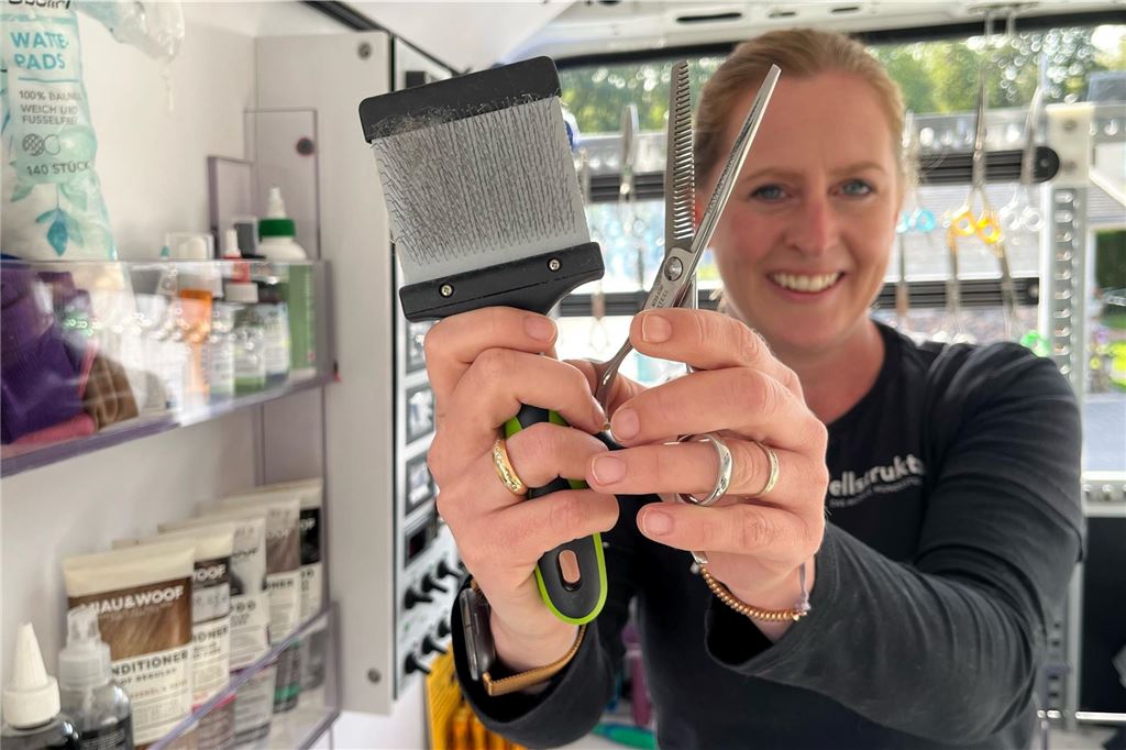 Friseursalon für Hunde: Anika Beierle ist mit dem „Fellmobil“ unterwegs Anika Beierle hält eine Bürste und eine Schere in die Kamera