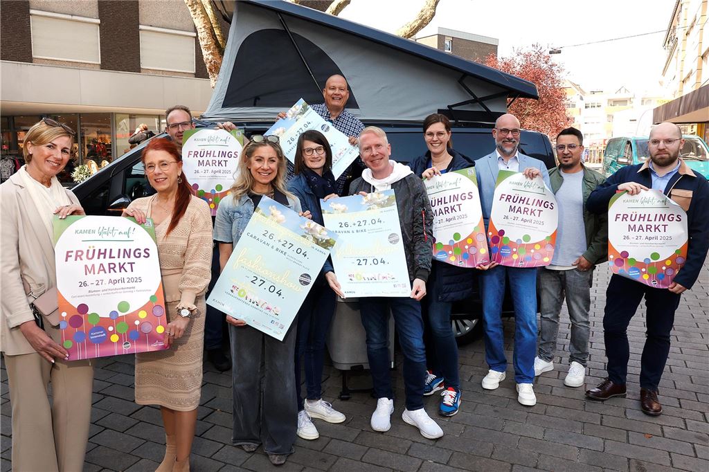 Kamen blüht beim Frühlingsmarkt in der Innenstadt zum zweiten Mal auf Frauen und Männer halten Plakate für den Frühlingsmarkt 2025 in Kamen in die Kamera.