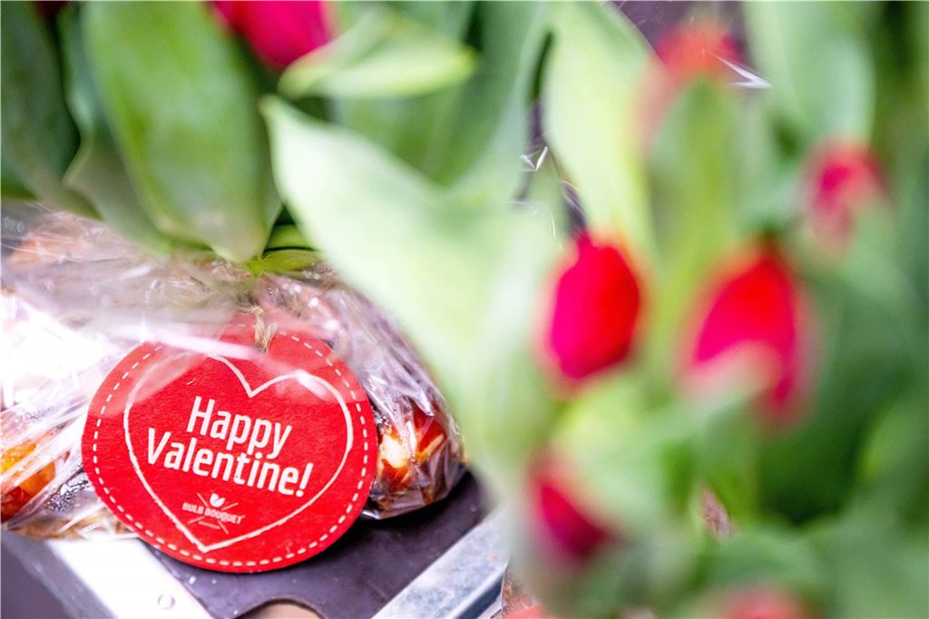 Restaurant-Aktionen zum Valentinstag: Romantische Menüs und Live-Musik „Happy Valentine!“, steht auf einem Anhänger von einem Blumenstrauß.