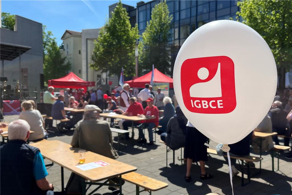 Alfred Buß rüttelt auf: Solidarität nicht nur unter Milliardären Auf dem Platz der Kulturen in Unna sitzen Gäste der Maikundgebung an Biertischen. Ein Luftballon von der IGBCE schwebt im Vordergrund.