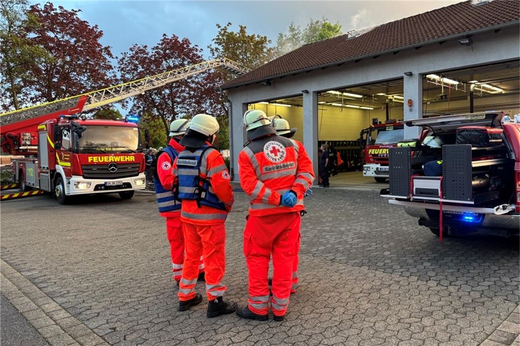Sanitäter des DRK stehen vor dem Gerätehaus in Weddinghofen.