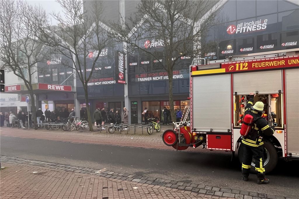 Rewe und Fitnessstudio geräumt wegen Feueralarm Während eines Einsatzes an der Flügelstraße steht ein Feuerwehrfahrzeug vor dem Gebäudekomplex mit Rewe-Markt und All-Inclusive-Fitnessstudio