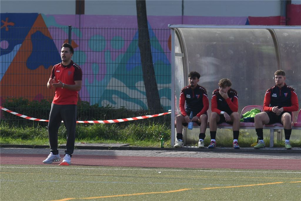 Die Krise des Werner SC spitzt sich weiter zu Ein Trainer im roten Shirt steht am Spielfeldrand bei sonnigem Wetter.