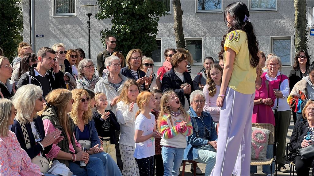 Zahlreiche Besucherinnen und Besucher genießen das sonnige Wetter bei der Modenschau von DekoRieger.