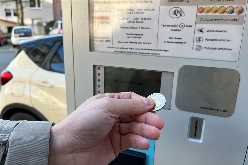 Belastungsprobe für Schwarzgrün: Rudolf Fröhlich ist angezählt Ein Mann steckt ein Zwei-Euro-Stück in einen Parkscheinautomaten in Unna.
