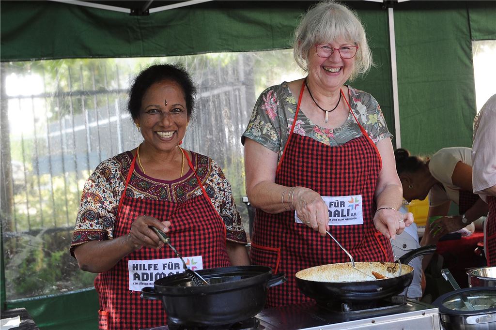 Diese Veranstaltungen gibt es im Sommer 2024 in Schwerte Zwei Frauen vom Verein "Hilfe für Adimali" stehen hinter einem Verkaufstisch. Sie backen Reibekuchen beim Pannekaukenfest in Schwerte.