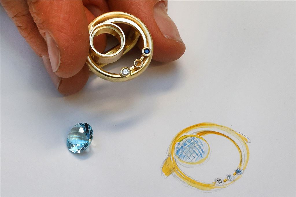Wunderschmuck von Telgmann: Neues Leben für Gold und Edelsteine Zwei Eheringe, die zu einem Ring verarbeitet werden. Daneben ist eine Zeichnung, wie die Arbeit der Goldschmiedin Stephanie Telgmann am Ende aussehen soll.